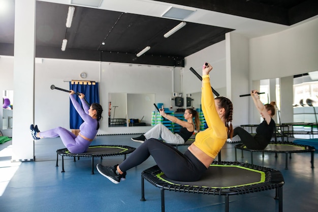 Vier junge Frauen auf dem Trampolin junge Fitness-Mädchen trainieren im Fitnessstudio