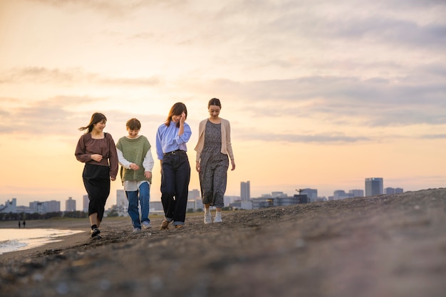 Vier junge frauen, die in der dämmerung am meer entlang gehen