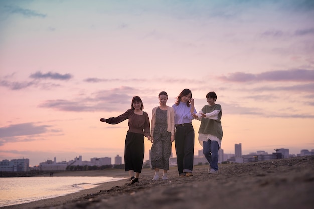 Vier junge Frauen, die in der Dämmerung am Meer entlang gehen