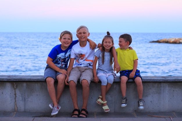 Vier Kinder am Strand Berufung Junge Familie im Urlaub haben viel Spaß