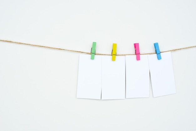 Foto vier leere weiße karten hängen an farbigen wäscheklammern platz für text-tags wort fourletters mockup