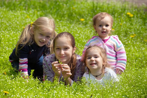 Vier Mädchen, die draußen auf Gras liegen