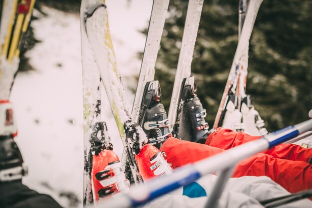 Vier nicht erkennbare Skifahrer fahren auf Skilift. Fokus eines Skis.