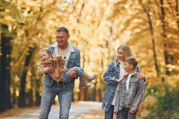 Vier Personen Glückliche Familie ist zur Herbstzeit zusammen im Park