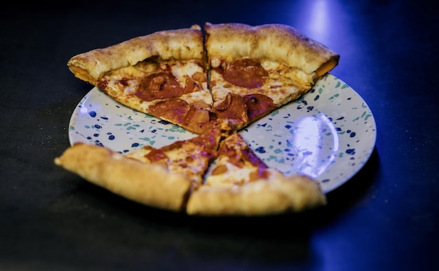 Vier Scheiben köstliche Peperoni-Pizza auf einem Teller