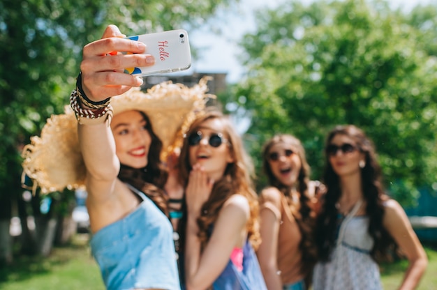 vier schöne Mädchen Hippies, die draußen selfie tun