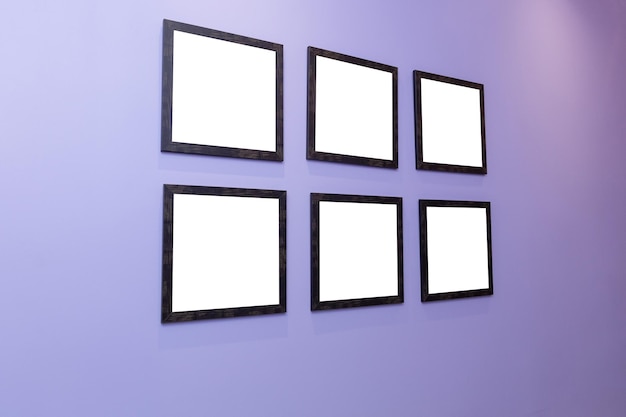 Vier schwarze Rahmen an einer violetten Wand mit weißem Hintergrund.