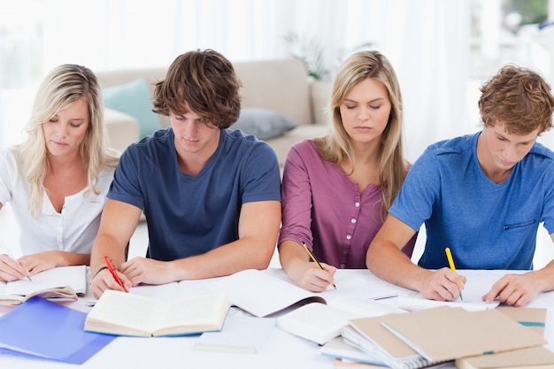 Foto vier studenten zusammensitzen und studieren