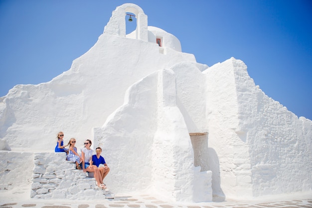 Vierköpfige Familie auf der Treppe von Paraportiani-Kirche auf Mykonos-Insel, in Griechenland