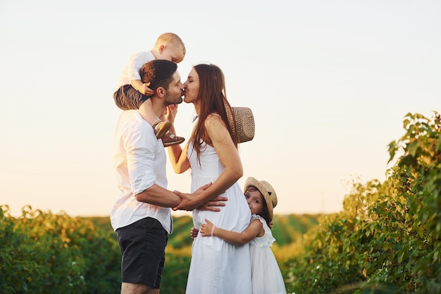 Vierköpfige Familie, die an sonnigen Sommertagen Freizeit auf dem Feld verbringt