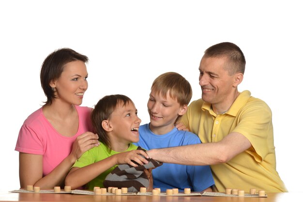 Vierköpfige Familie spielt Lotto auf weißem Hintergrund