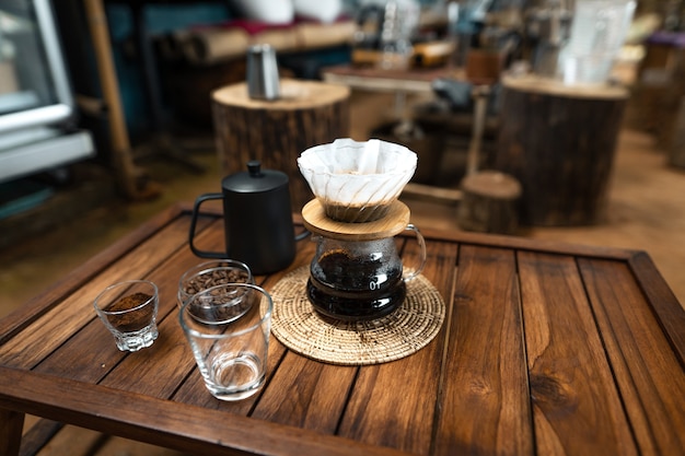 Vierta agua caliente en el café., Gotee el café sobre una mesa de madera en casa