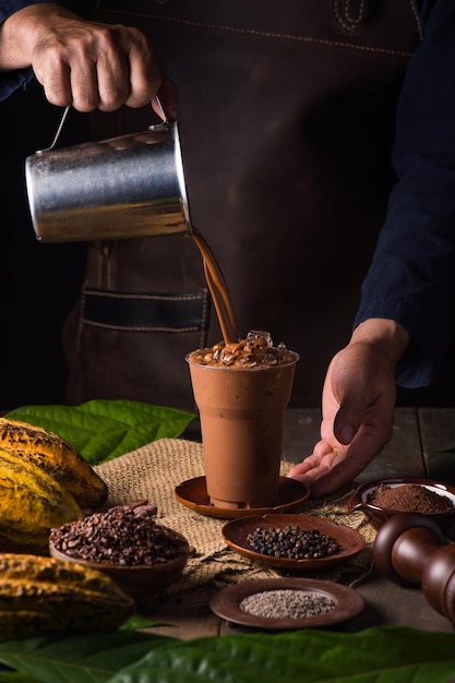 Vierta una deliciosa bebida de cacao con chocolate caliente en una taza con fondo negro de bajo perfil de mesa negra