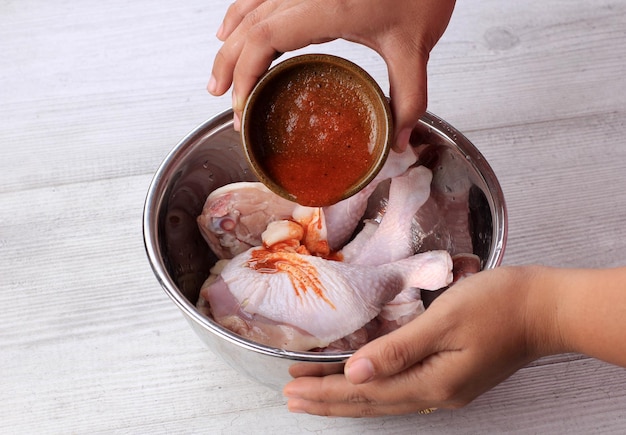 Vierta pasta de especias picantes en muslos de pollo, haciendo pollo asado paso a paso proceso de cocción en la cocina