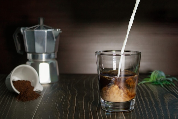 Se vierte la leche en la taza de café. Enfoque selectivo