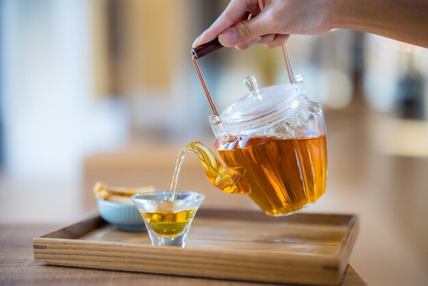 Foto vierte el té en un vaso de agua.