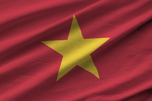 Vietnam-Flagge mit großen Falten, die in der Nähe unter dem Studiolicht im Innenbereich die offiziellen Symbole und