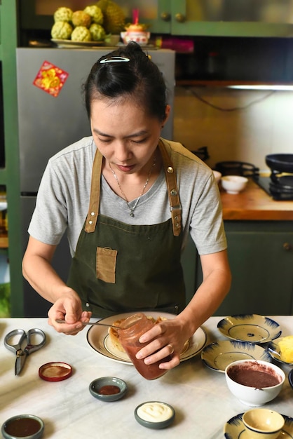 Vietnamesin in Schürze, die auf dem Tisch serviert wird