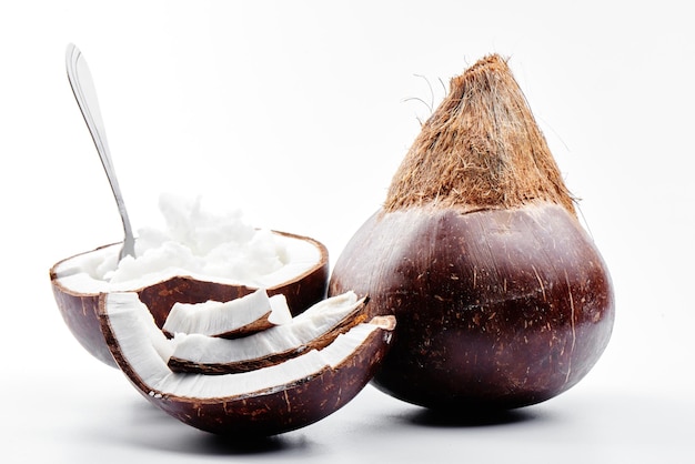 Vietnamesische braune Kokosnüsse mit Kokosöl im Inneren auf weißem Hintergrund