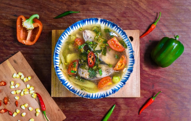 Vietnamesische Suppe mit Fisch und Gemüse auf Holztisch