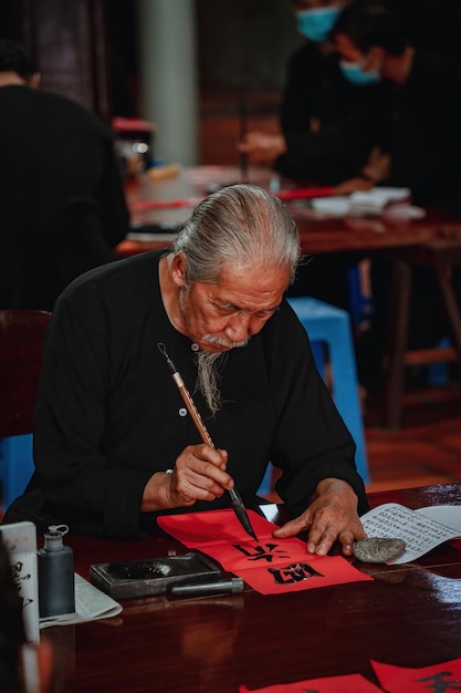 Vietnamesischer Gelehrter schreibt Kalligrafie beim Long Son Kalligrafiefestival ist eine beliebte Tradition während der Tet-Feiertage Verse für das Frühlingsfest im neuen Jahr schreiben