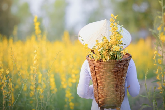 Vietnamesisches Mädchen mit gelben Blumen.