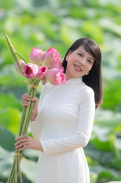Vietnamesisches Mädchen mit rosa Lotus am Morgen