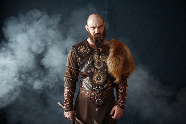 Vikingo barbudo con hacha vestida con ropas tradicionales nórdicas