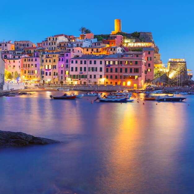 Vila de pescadores noturnos Vernazza com torre de vigia do Castelo de Doria para proteger a vila de piratas, Cinco terras, Parque Nacional de Cinque Terre, Ligúria, Itália.