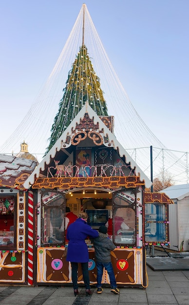 Vilnius, Litauen - 4. Dezember 2016: Weihnachtssüßigkeitshaus und Besucher am Weihnachtsmarkt auf dem Domplatz, Vilnius, Litauen. Während der Adventszeit