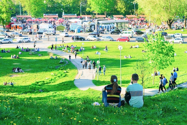 Vilnius, Lituania - 19 de mayo de 2017: Jóvenes sentados en el césped mientras celebran el festival de comida Open Kitchen en Vilnius, Lituania.