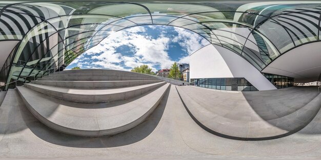 VILNIUS LITUANIA MAYO 2019 Panorama esférico completo ángulo de 360 grados cerca de la fachada de un edificio moderno torcido con un enorme vidrio espejado en proyección equirectangular VR AR contenido