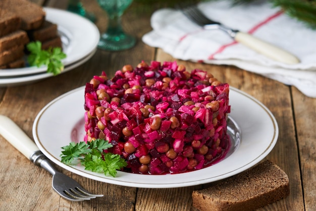 Vinagreta de ensalada de verduras con remolacha, papas, pepinillos y guisantes en un plato