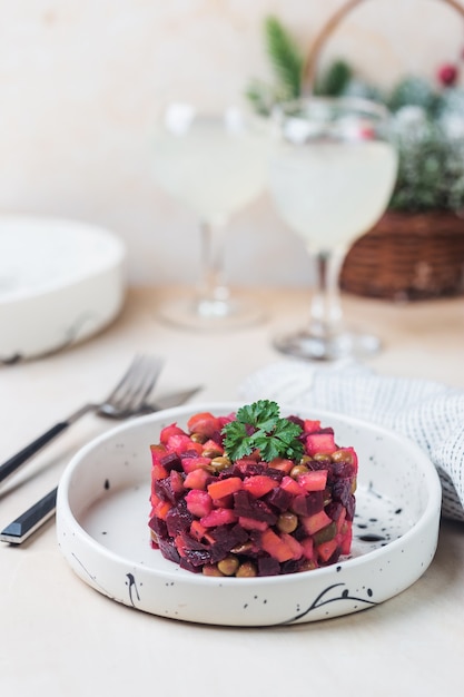 Vinagrete de salada de beterraba russa em um prato branco sobre fundo claro