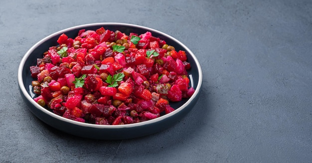 Vinagrete de salada tradicional com legumes de beterraba e ervilhas em fundo grafite