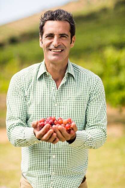 Foto vinatero sonriente con uvas