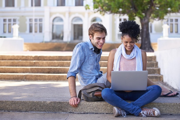 Vinculación a través de las ventajas de la tecnología Toma de dos estudiantes universitarios que estudian juntos en los terrenos del campus