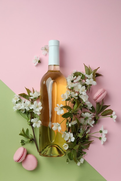 Vinho, biscoitos e flores em fundo de dois tons