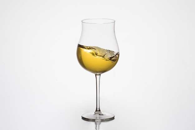 Foto vinho branco em movimento em adegas de vinificação de vidro tulipa fundo brancoxa