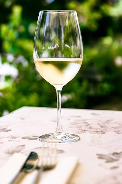 Vinho branco em restaurante de luxo no terraço com jardim de verão experiência de degustação de vinhos em vinícola na vi ...