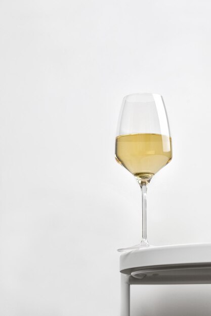 Vinho branco em vidro rico em uma mesa redonda branca. minimalismo. elegante