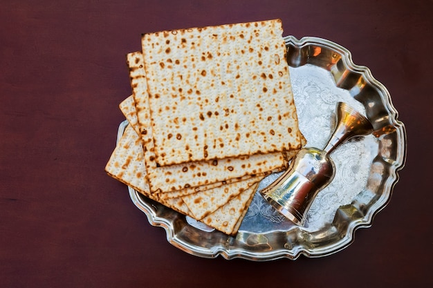 Vinho de vista superior e pão de Páscoa judaica matzoh sobre fundo de madeira.