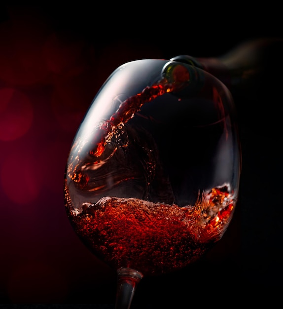 Vinho derramando em copo de vinho em um fundo vínico