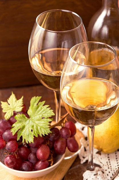 Vinho e uvas em ambiente vintage na mesa de madeira