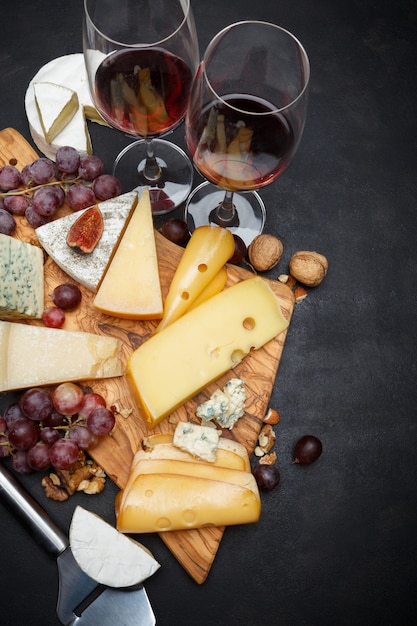 Vinho e vários tipos de queijo - parmesão, brie, roquefort, queijo cheddar