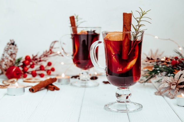 Vinho quente caseiro com quentão com alecrim em prato branco em clima de ano novo.