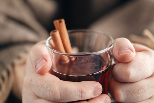 Foto vinho quente com especiarias caseiro na mão, vinho quente