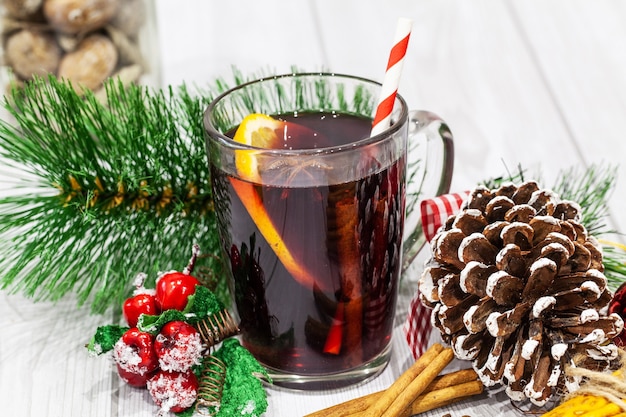 Vinho quente com especiarias com especiarias em fundo de natal.