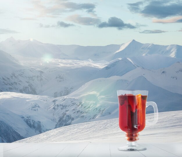 Vinho quente com especiarias e paisagem de montanhas ao fundo Álcool bebida quente