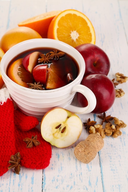 Vinho quente com especiarias em uma tigela em close-up de mesa de madeira